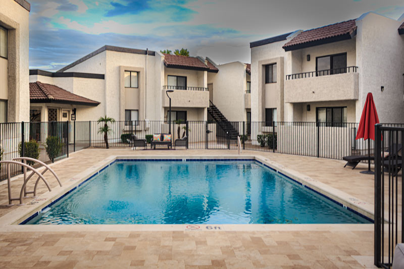 Front view of a residential pool enclosed by apartment buildings.